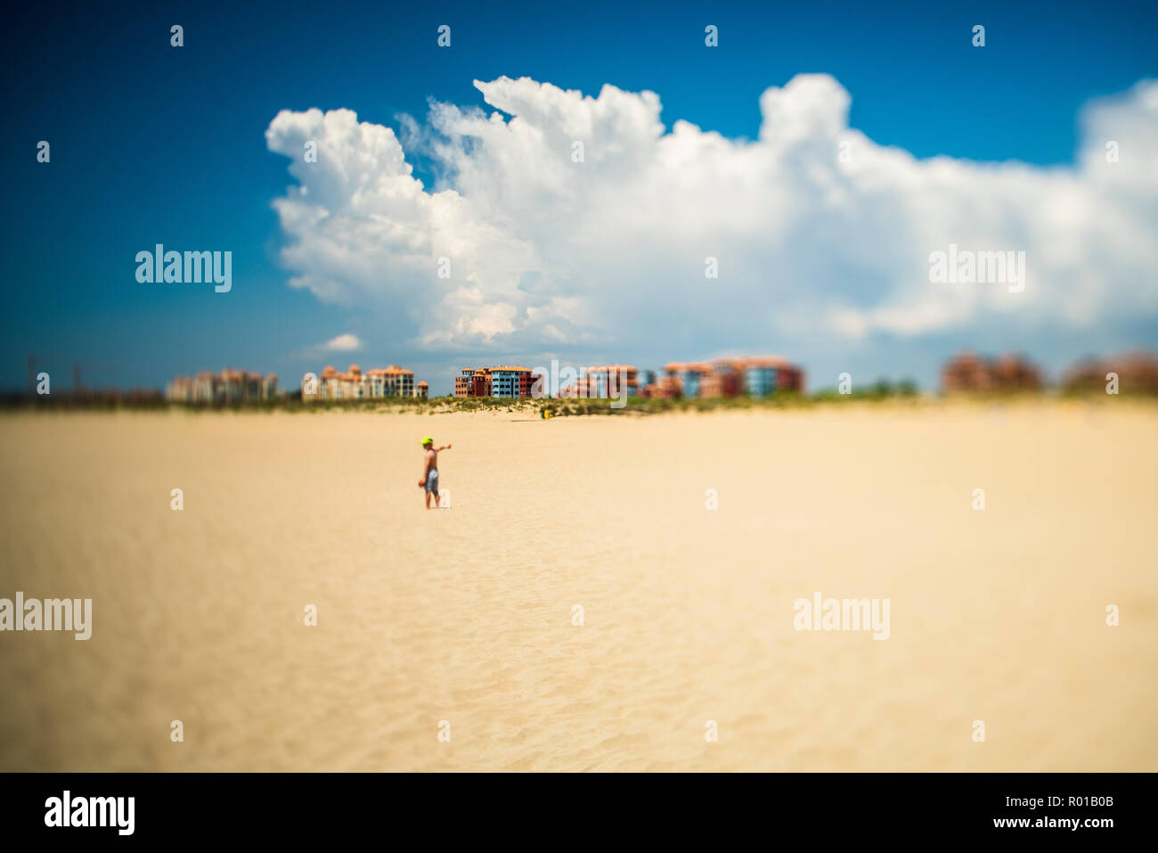 Ein Kind allein am Strand, Ayamonte, Spanien. Ein gekipptes Objektiv wurde für einen geringeren Schärfentiefe verwendet. Stockfoto
