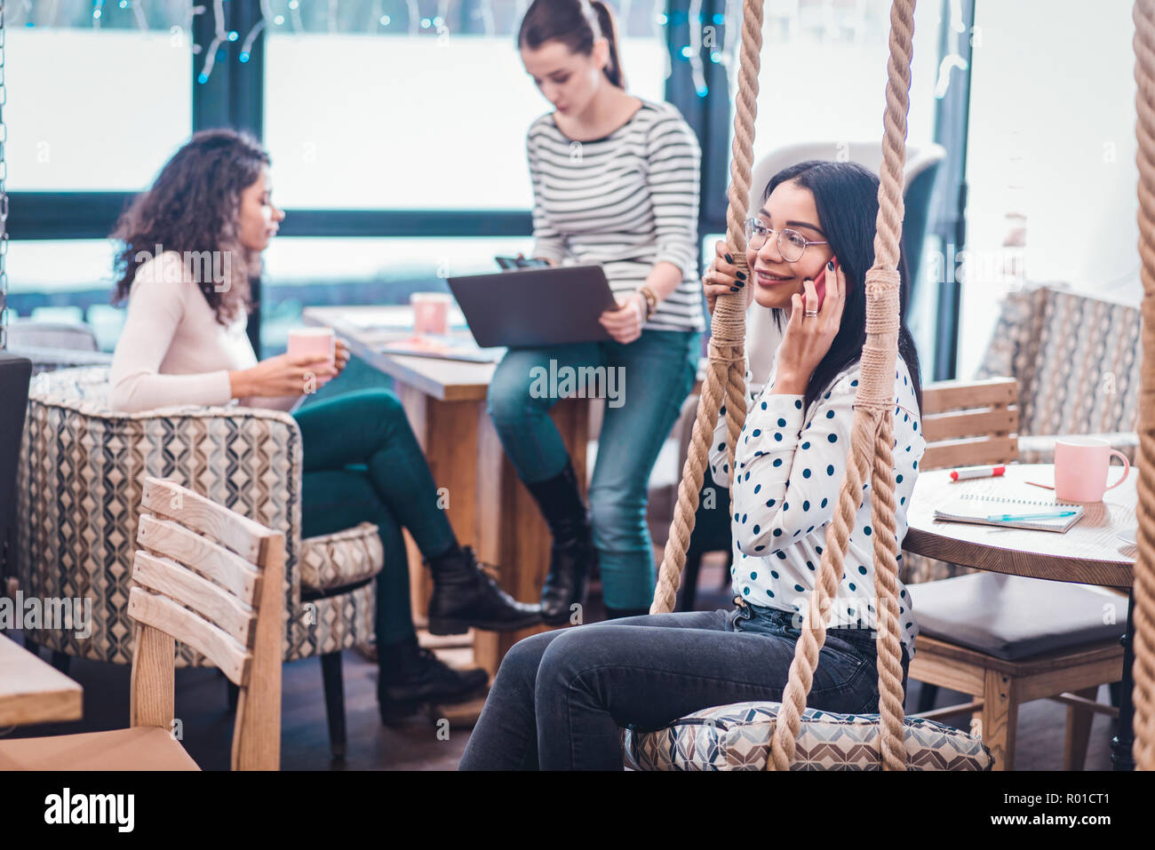 Freudige nette Frau, ein Handy an ihr Ohr Stockfoto