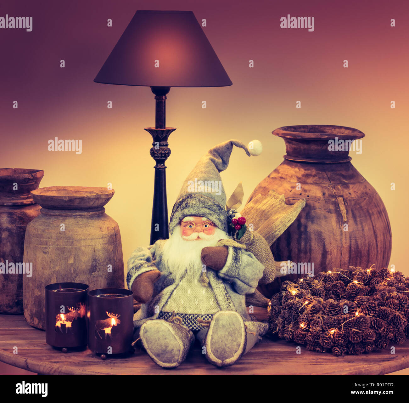 Weihnachtsbaum Szene: Stillleben mit Lampe, Teelicht Kerzen, Santa Claus Doll, beleuchteter Kranz und alten hölzernen Vasen. Stockfoto