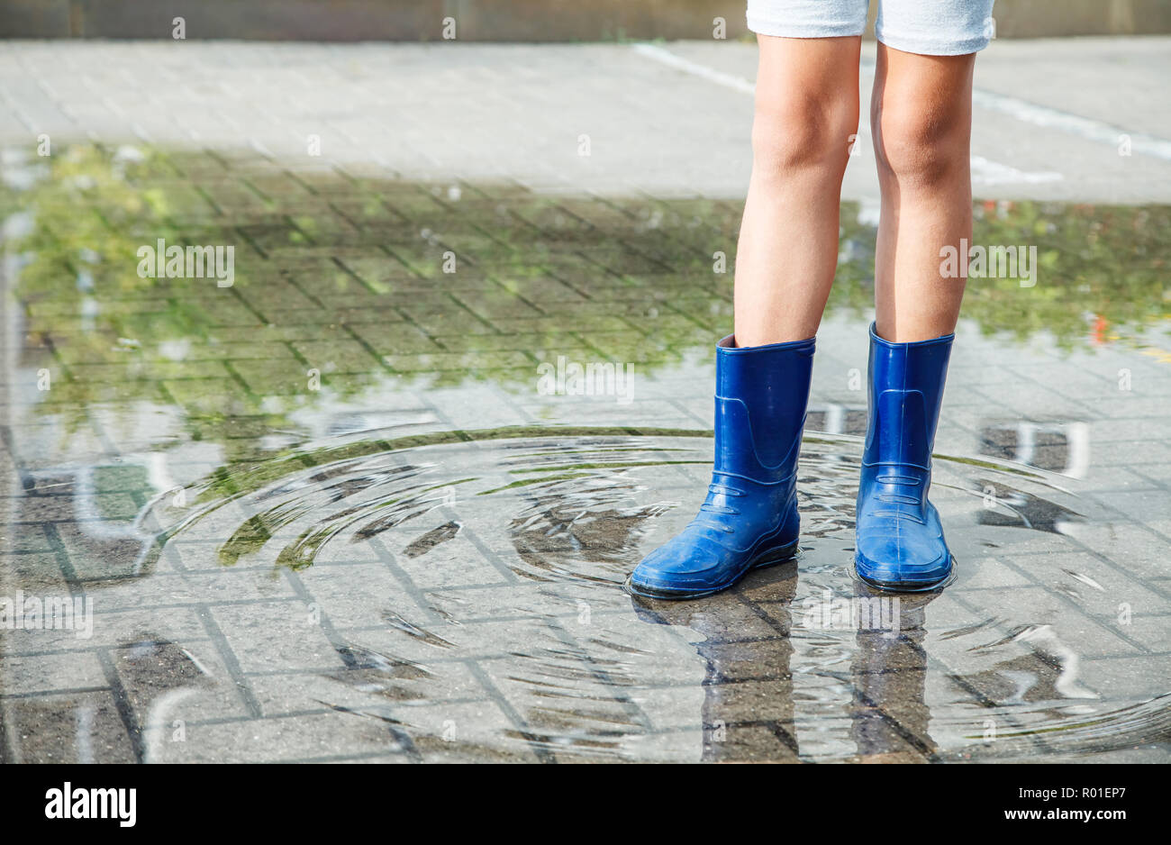 Mädchen in Gummistiefel in einer Pfütze stehen nach einem Regen im Sommer  im Freien Tag. Beine closeup Stockfotografie - Alamy
