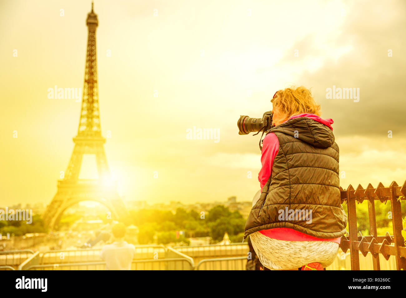 Fotograf auf der Place du Trocadero von Tour Eiffel bei Sonnenuntergang. Reisende Frau in Paris, Frankreich, Europa. Eiffelturm auf verschwommenen Hintergrund. Reisen und Tourismus in Europa. Stockfoto