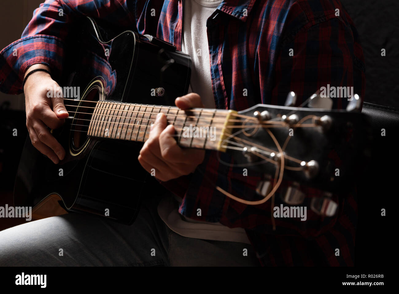 Junger Mann mit Gitarre, Ansicht schließen, dunklen Hintergrund Stockfoto