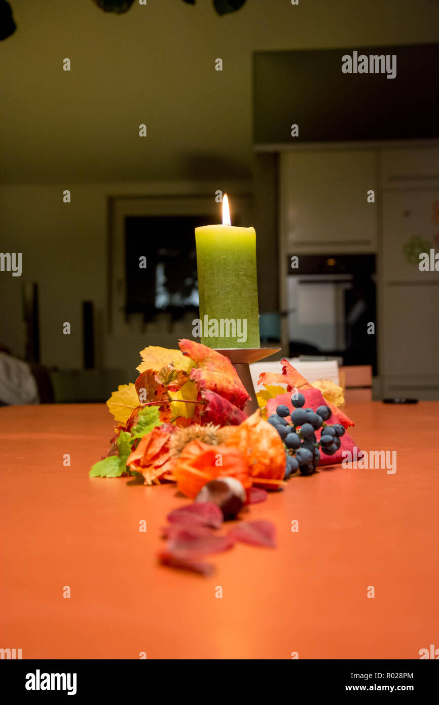 Herbst Dekoration mit einer brennenden Kerze auf dem Esstisch Stockfoto