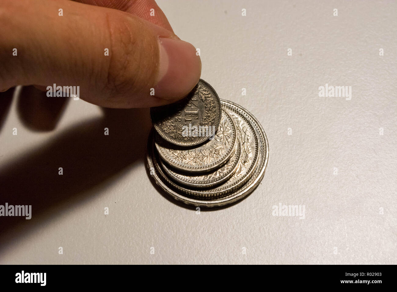 Die menschliche Hand die Münze von coin stack Franken Schweiz Stockfoto