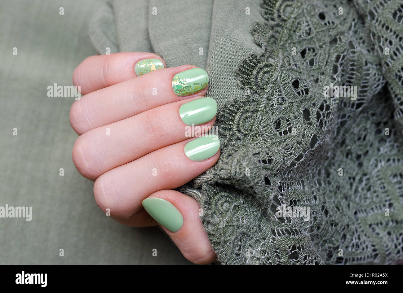 Schöne weibliche Hand mit grünem Nageldesign. Stockfoto