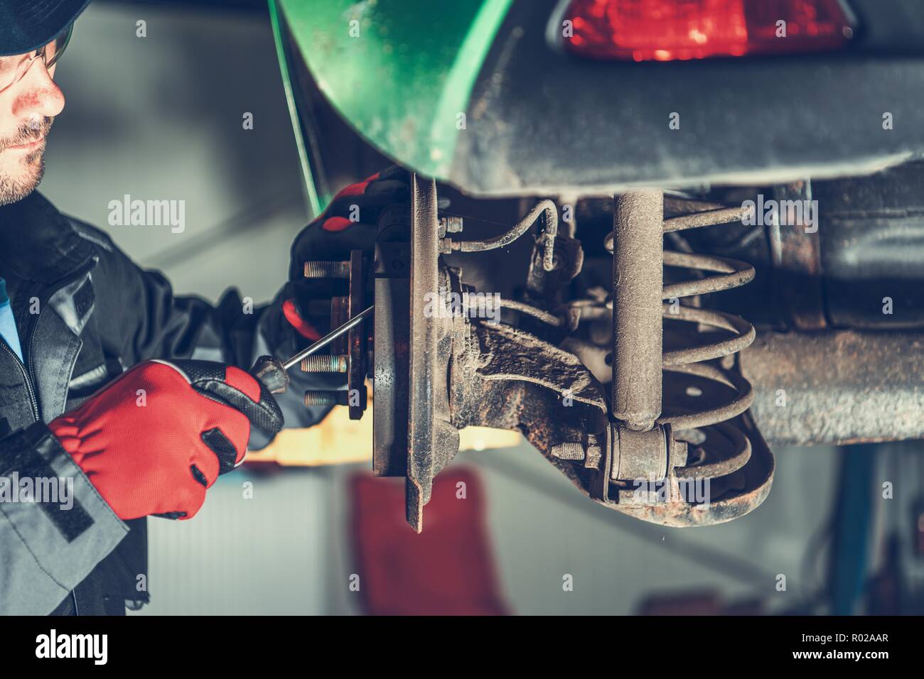 Wartung Auto Bremsen von kaukasischen Fahrzeug Mechaniker in seinen 30ern. Automotive Thema. Stockfoto