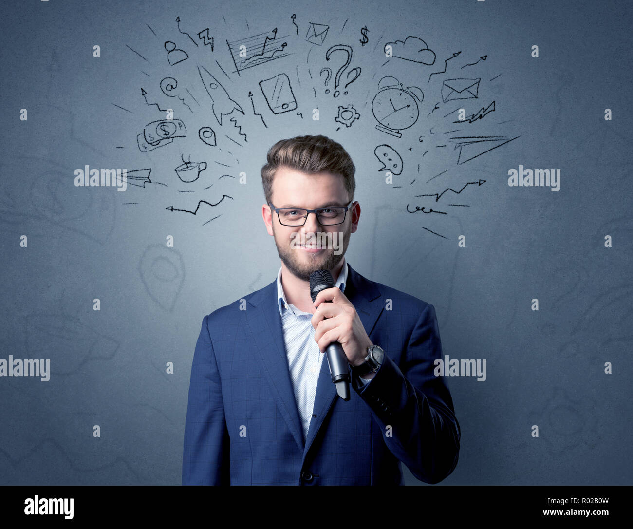 Geschäftsmann sprechen in das Mikrofon mit gemischten Doodles über seinem Kopf Stockfoto