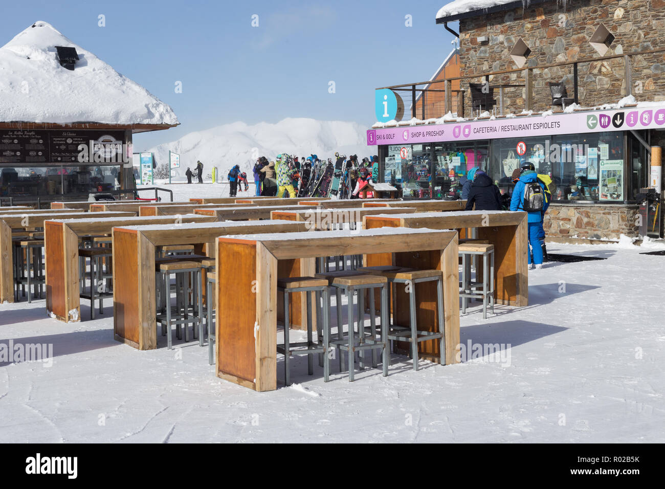 Pyrenäen, ANDORRA - Februar 6, 2018: Touristen in der Nähe der Tische der open-air Terrasse des Cafés im Skigebiet. In der Nähe des Store mit Sportgeräte ein Stockfoto