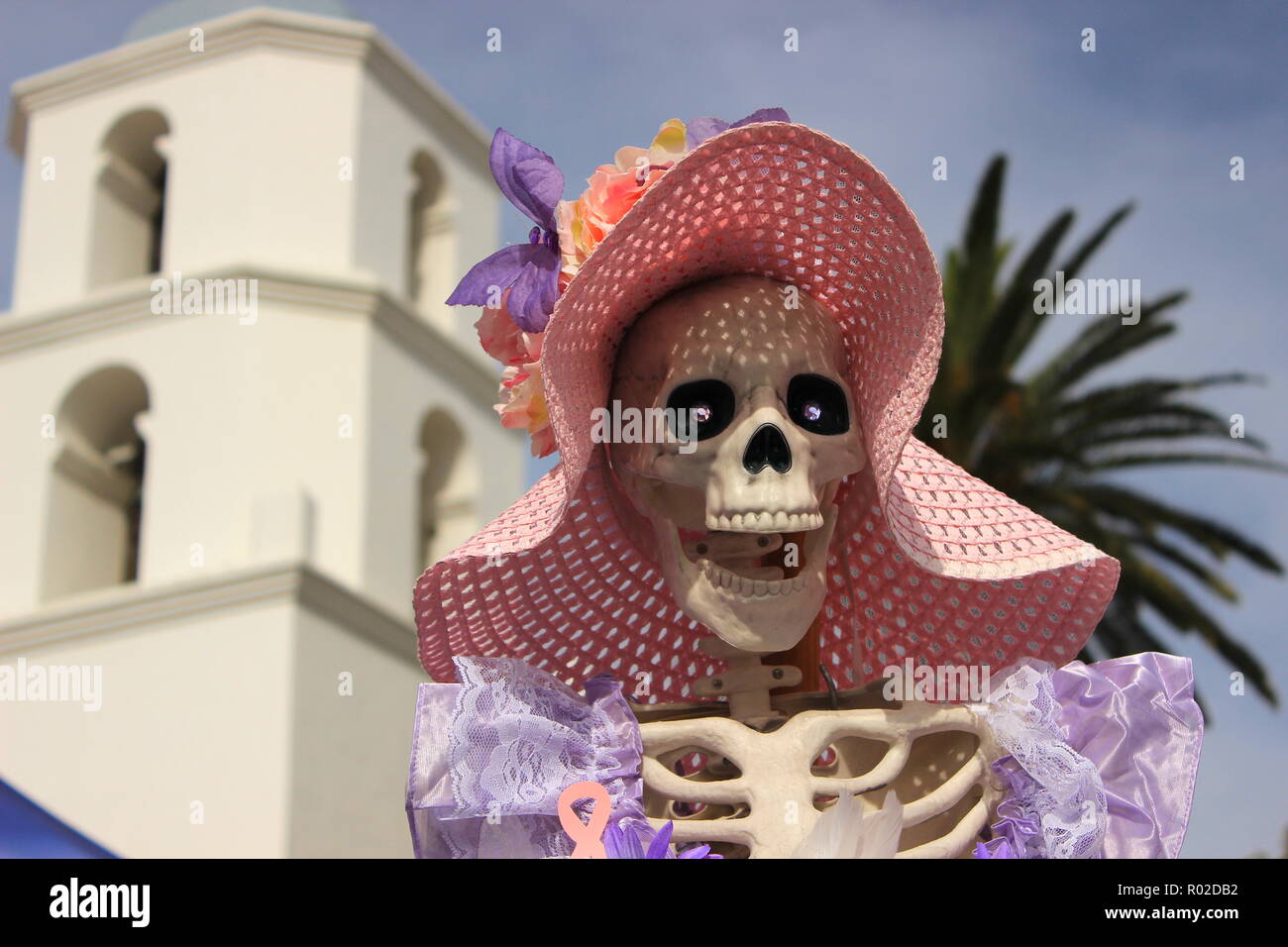 Ein catrina Abbildung während der Tag der Toten angezeigt (Dia de los U-Bahnen) Feier, Turm von San Luis Rey Mission im Hintergrund Stockfoto