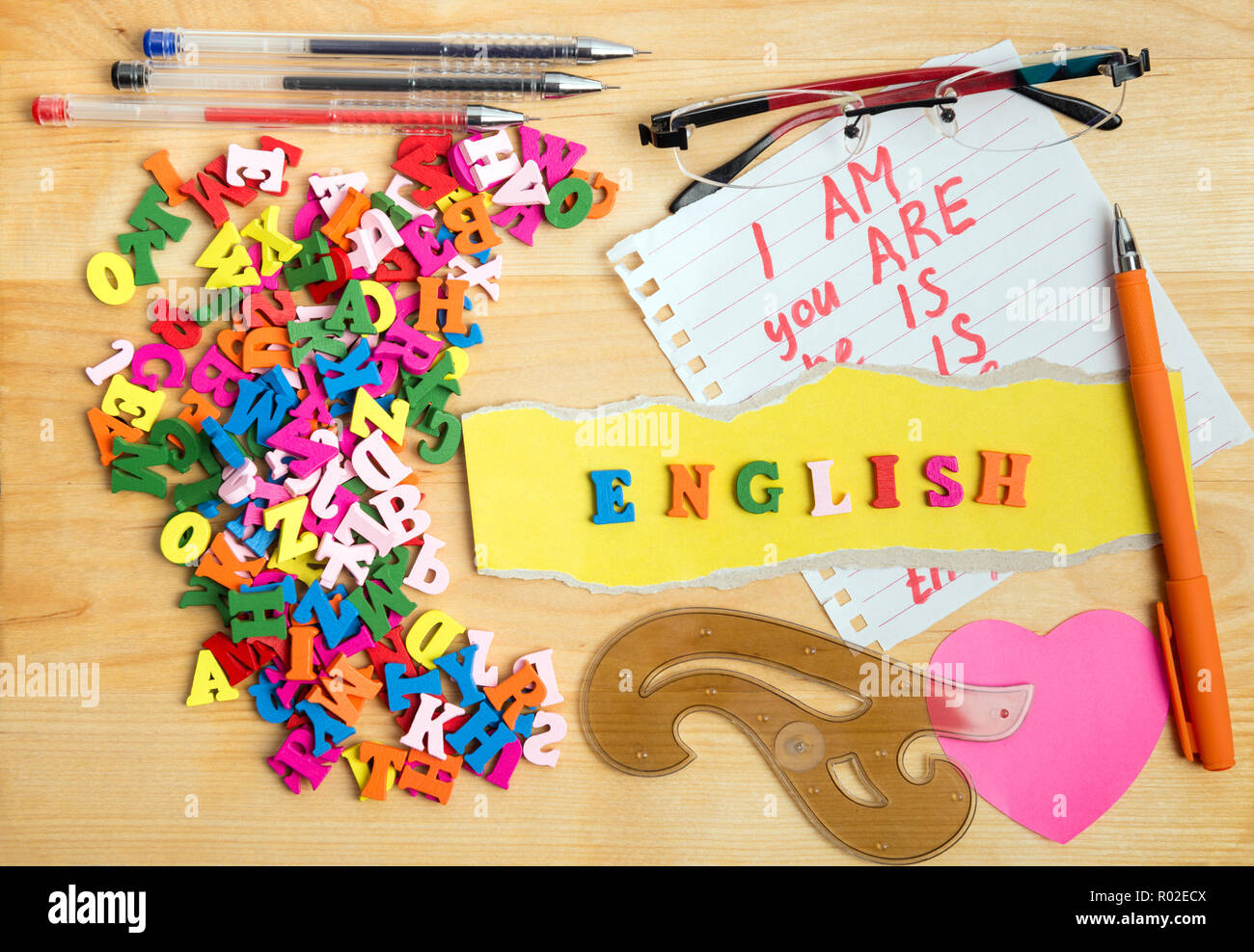 Englisch Holz- buchstaben und learning Material in der Nähe von einem Stapel von Briefen über Holz Vorstand Hintergrund Stockfoto