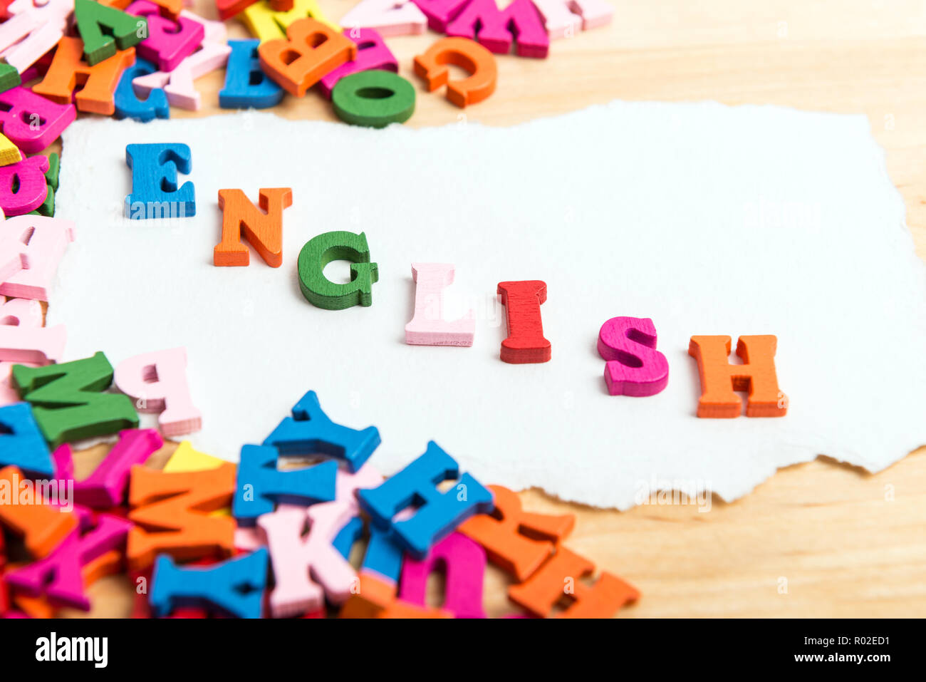 Englische Wort in Holz- Buchstaben in der Nähe von einem Stapel von Briefen über Holz Vorstand Hintergrund Stockfoto