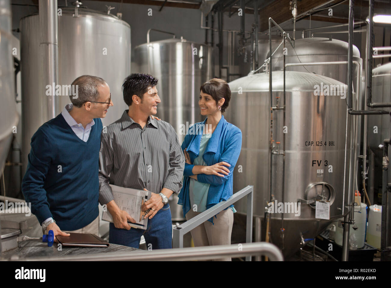 Drei Kollegen haben ein Geschäft Diskussion im Tankraum einer Brauerei. Stockfoto