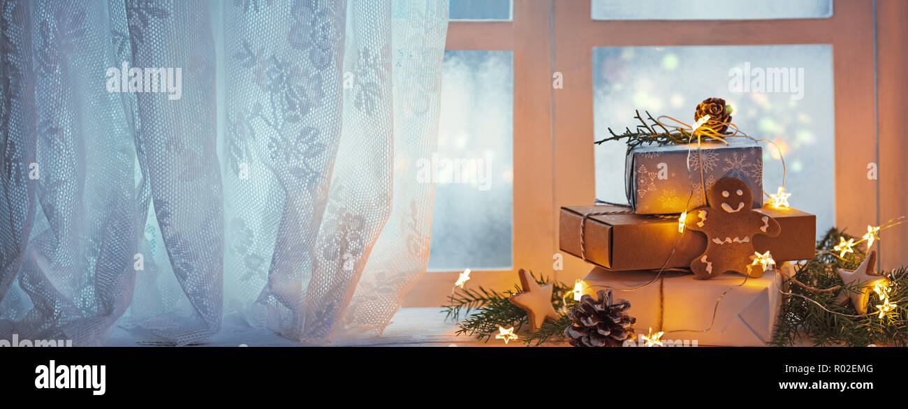 Frohe Weihnachten und schöne Feiertage Fenster mit Geschenkboxen und Leuchten, neues Jahr Dekoration. Stockfoto