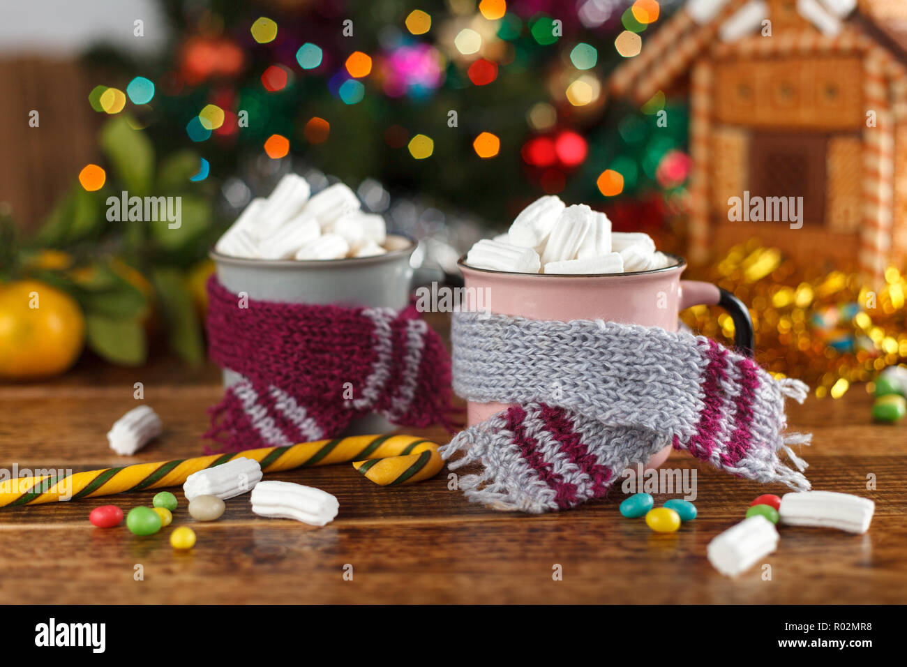 Cups mit Kakao und Marshmallow in der gemütlichen Schals auf dem Hintergrund der Weihnachtsbaum. Das neue Jahr noch leben. Stockfoto