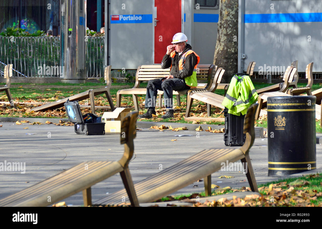 Arbeiter, der sich während des Austauschs der Bänke auf dem Leicester Square ausruhte. London, England, Großbritannien. Stockfoto
