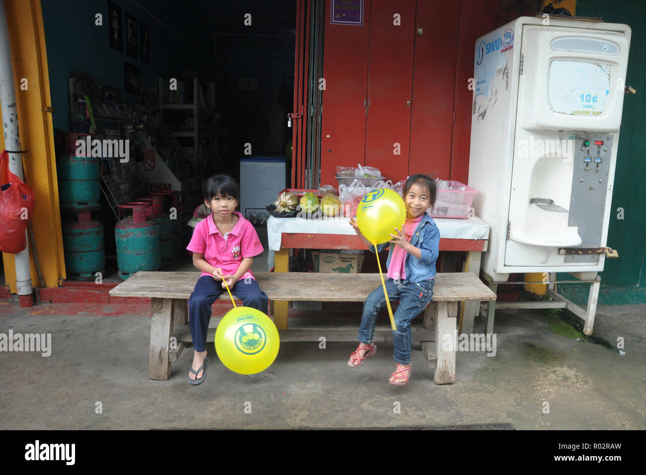 Kiulu Sabah Malaysia - 18.Oktober 2017: Zwei Kinder spielen mit beloon infront der Gemischtwarenladen in Kiulu Sabah. Kiulu ist eine der wichtigsten touristischen Reiseziele in Stockfoto