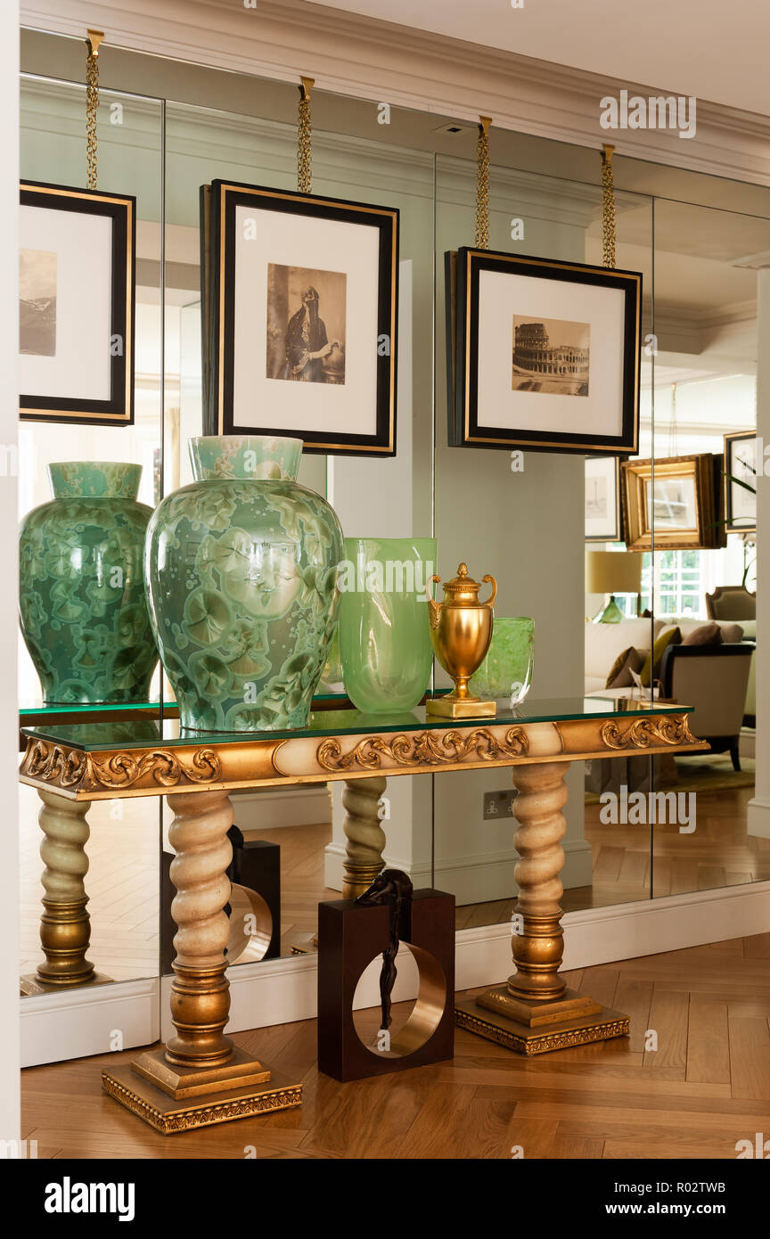 Vasen auf Gold Tabelle durch verspiegelte Wand Stockfoto