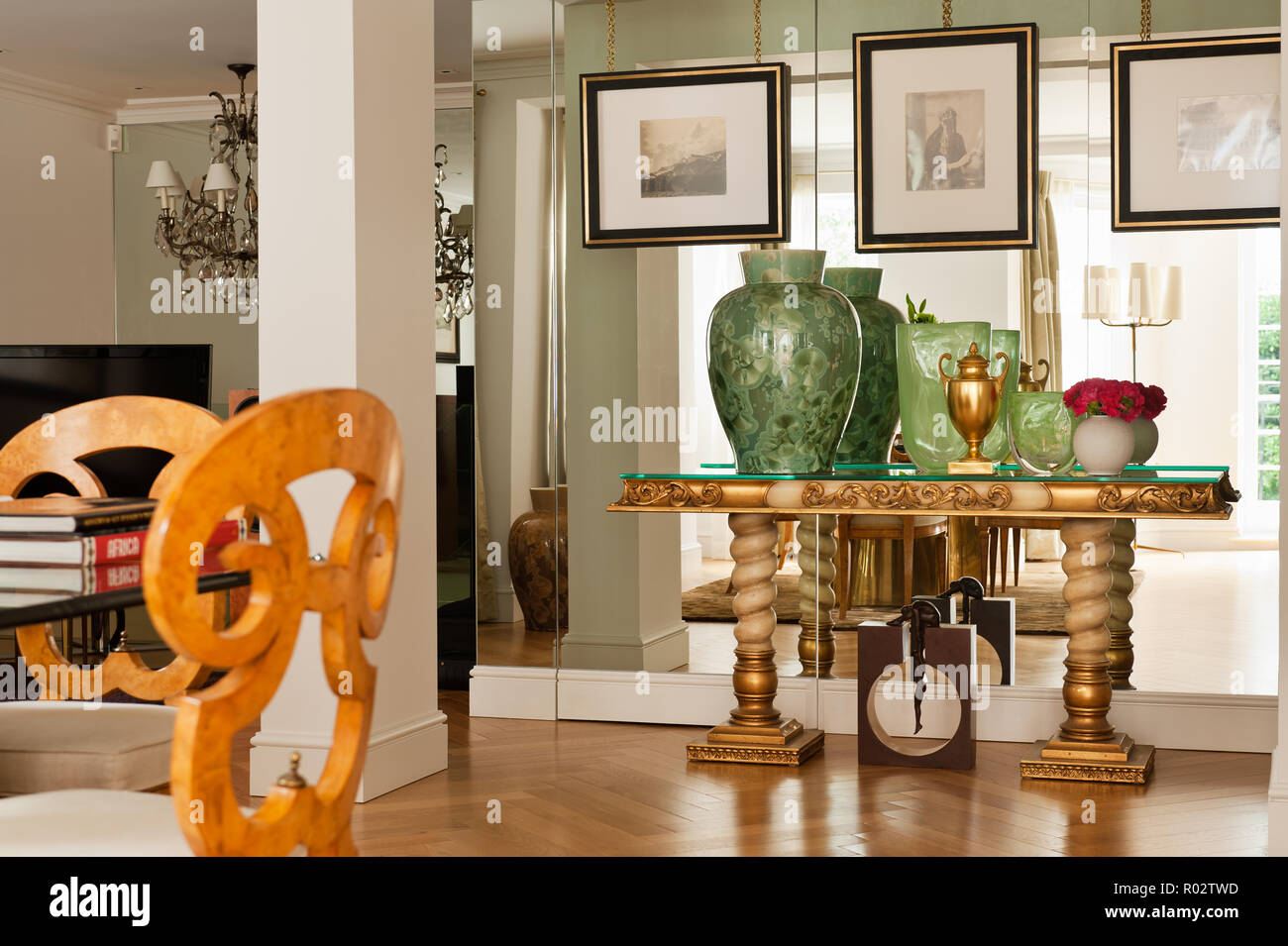 Vasen auf Gold Tabelle durch verspiegelte Wand Stockfoto