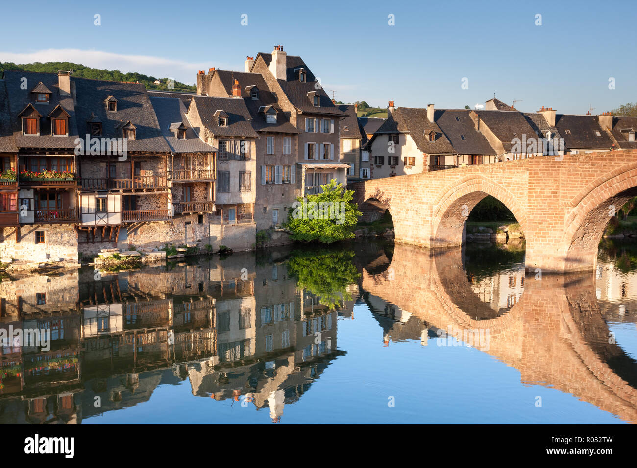 Riverside Häuser und gewölbte Brücke in den Fluss von Estaign Frankreich wider Stockfoto
