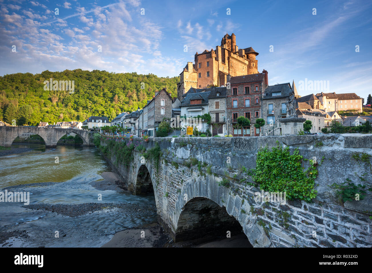 Französisches Dorf und das Schloss Estaign Frankreich mit der gewölbten Brücke und Fluss im Vordergrund bei Sonnenaufgang Stockfoto