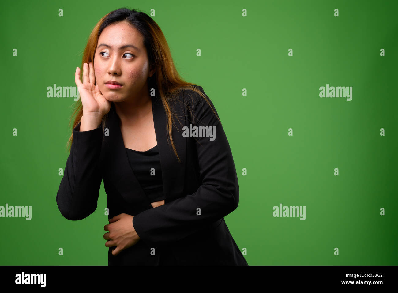 Portrait von jungen asiatischen Geschäftsfrau vor grünem Hintergrund Stockfoto