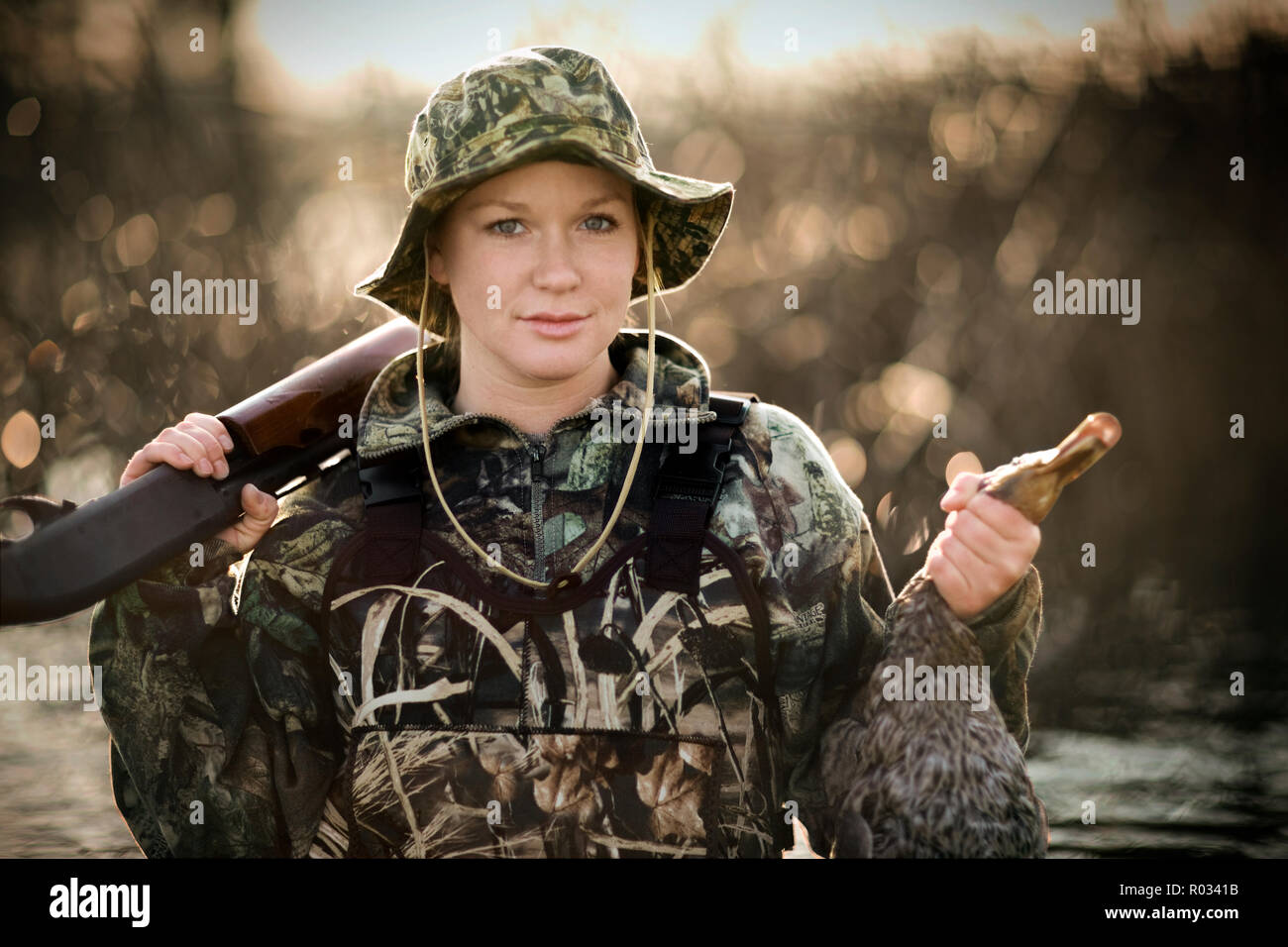 Porträt eines jungen erwachsenen Frau Duck Shooting an einem See. Stockfoto