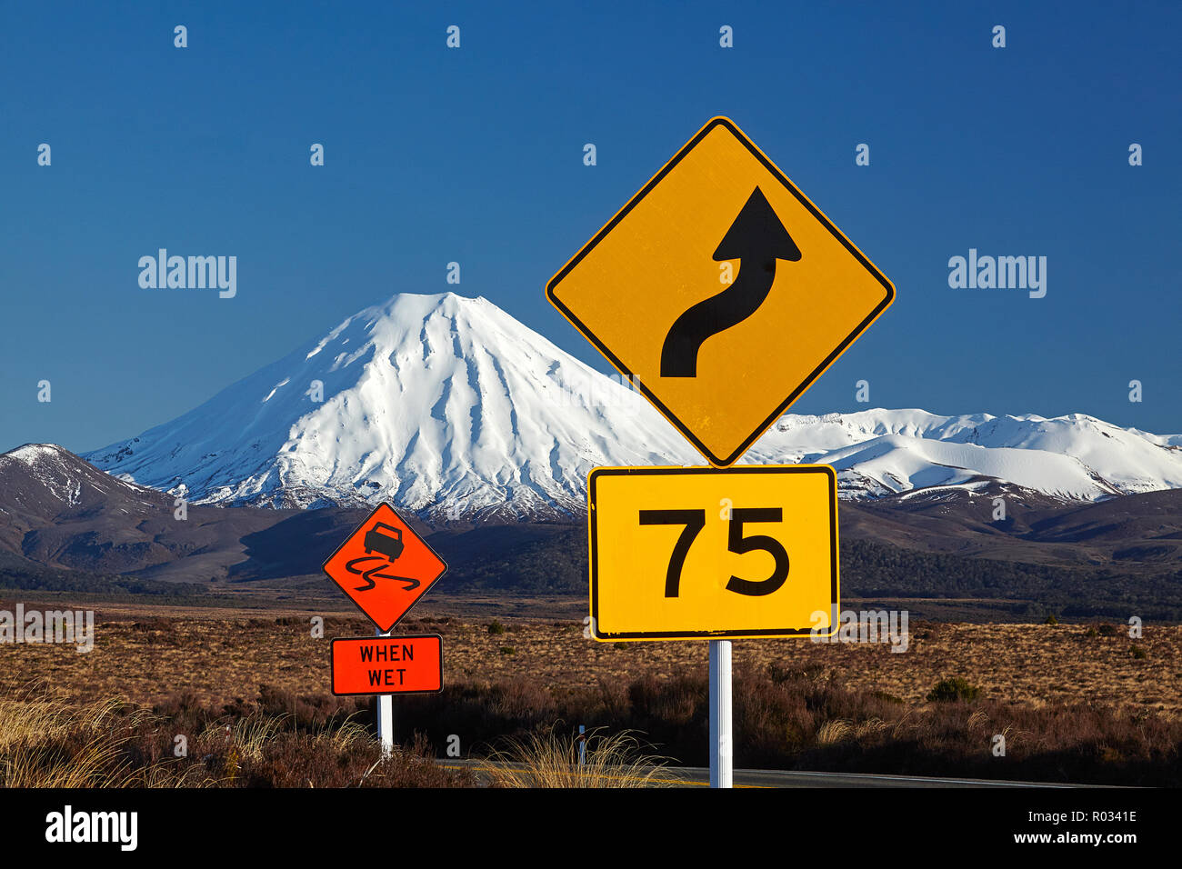 Verkehrszeichen auf Wüste Straße und Mt Ngauruhoe, Tongariro National Park, Central Plateau, North Island, Neuseeland Stockfoto