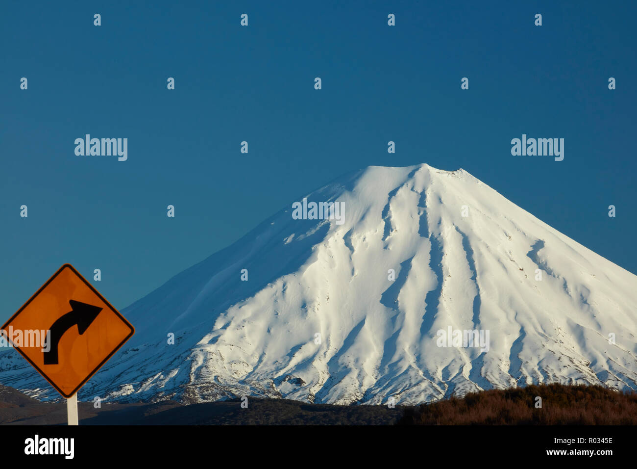 Ecke Zeichen auf Wüste Straße und Mt Ngauruhoe, Tongariro National Park, Central Plateau, North Island, Neuseeland Stockfoto