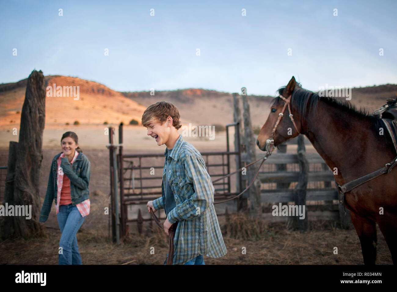 Zwei lächelnde Jugendliche in einem stabil auf einer Ranch. Stockfoto