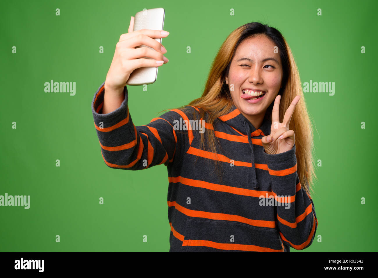 Portrait von jungen asiatischen Frau gegen grüner Hintergrund Stockfoto