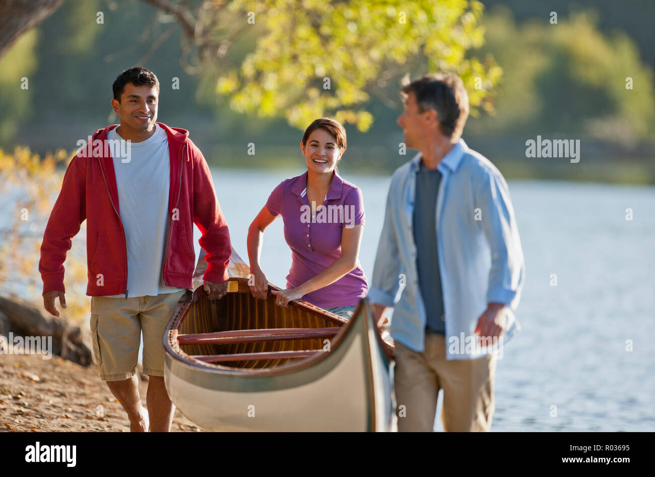 Freunde mit einem Kanu auf dem Weg zu einem See. Stockfoto