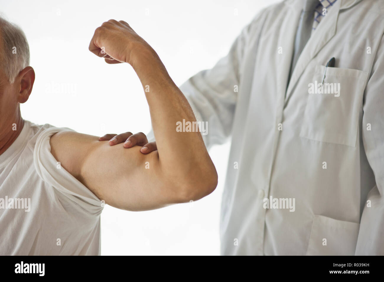 Arzt Gefühl gebeugt bicep Muskel des Patienten. Stockfoto