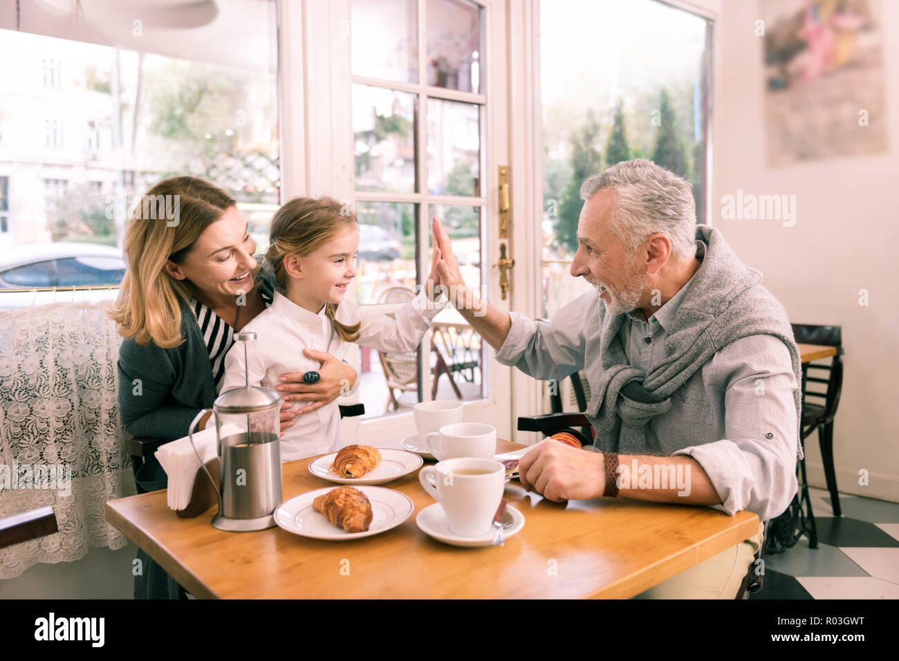 Moderne Großvater, fünf seiner niedlichen kleinen Enkelin Stockfoto