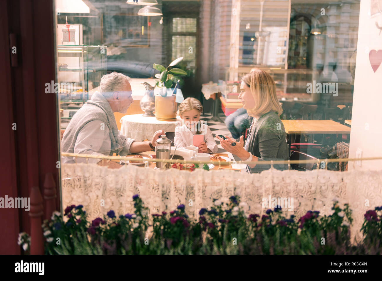 Glücklich liebende Großeltern ihren Geburtstag Mädchen in die Bäckerei Stockfoto
