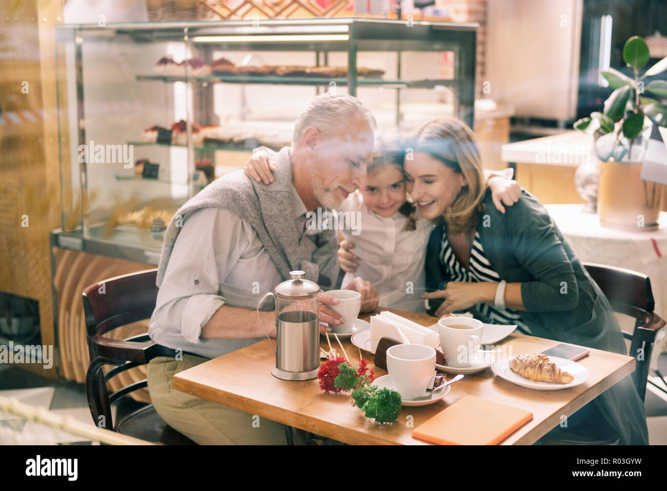 Liebende Enkelin tragen weiße Hemd ihre Großeltern umarmen Stockfoto