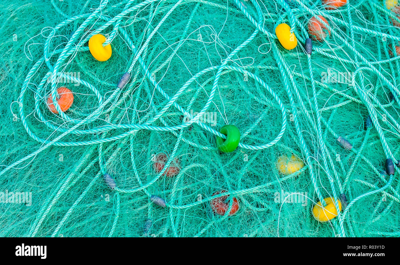 Türkisfarbene Fischernetz mit farbenfrohen Umzugswagen Stockfoto