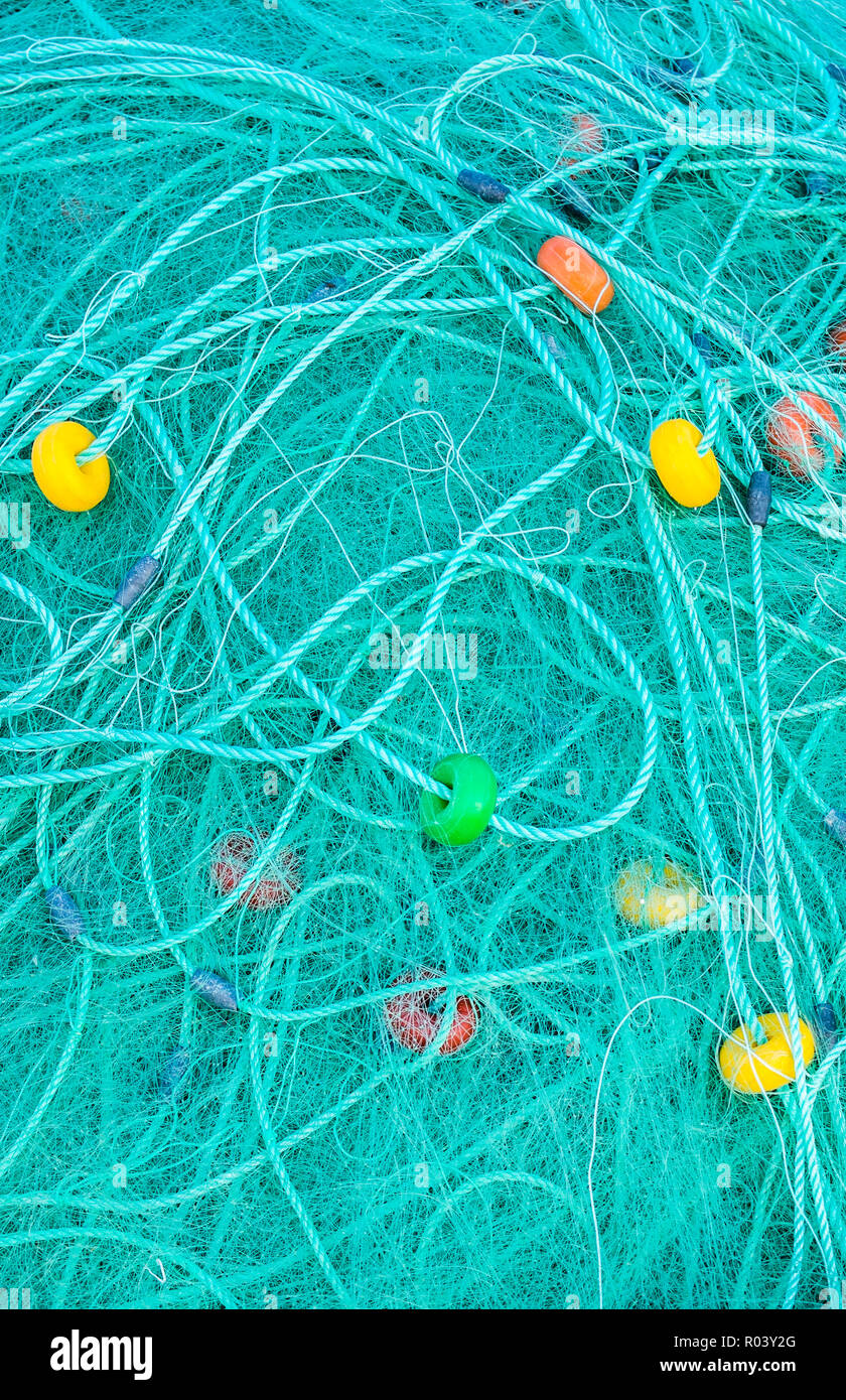 Türkisfarbene Fischernetz mit farbenfrohen Umzugswagen Stockfoto