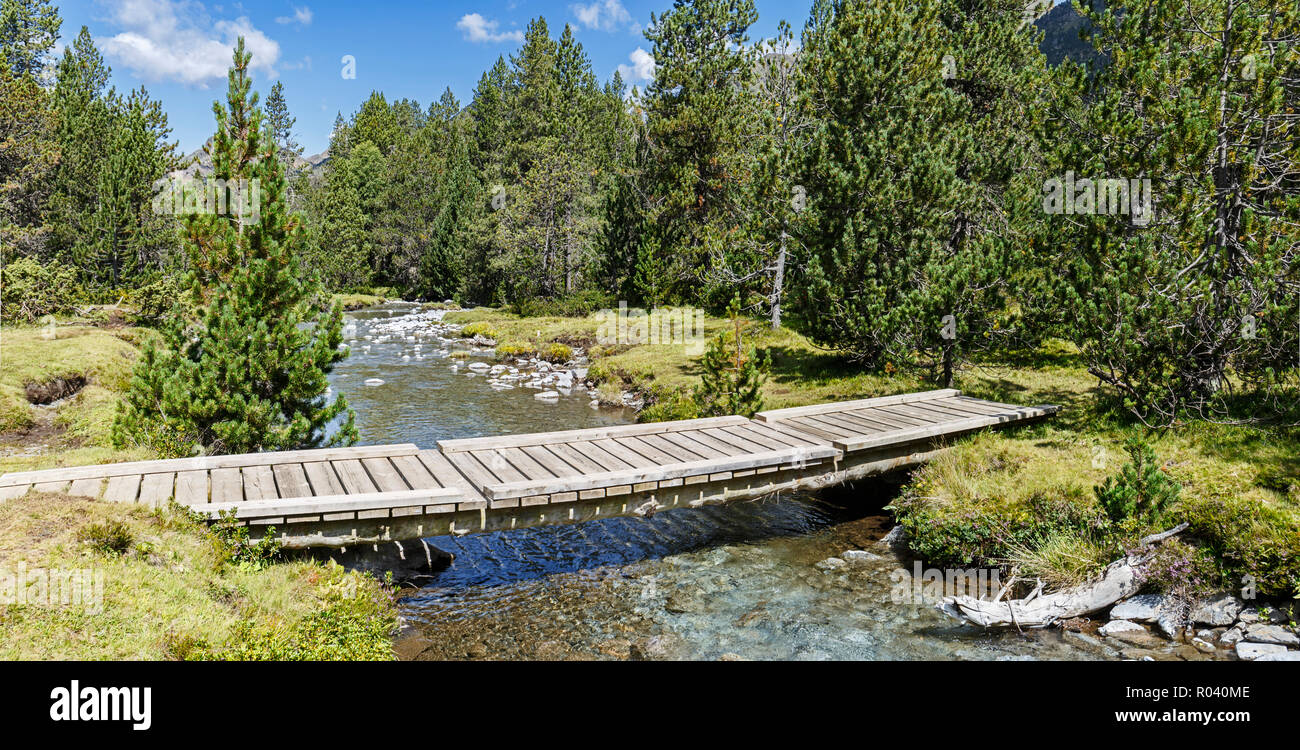 Hölzerne Brücke über einen Fluss in den katalanischen Pyrenäen Stockfoto