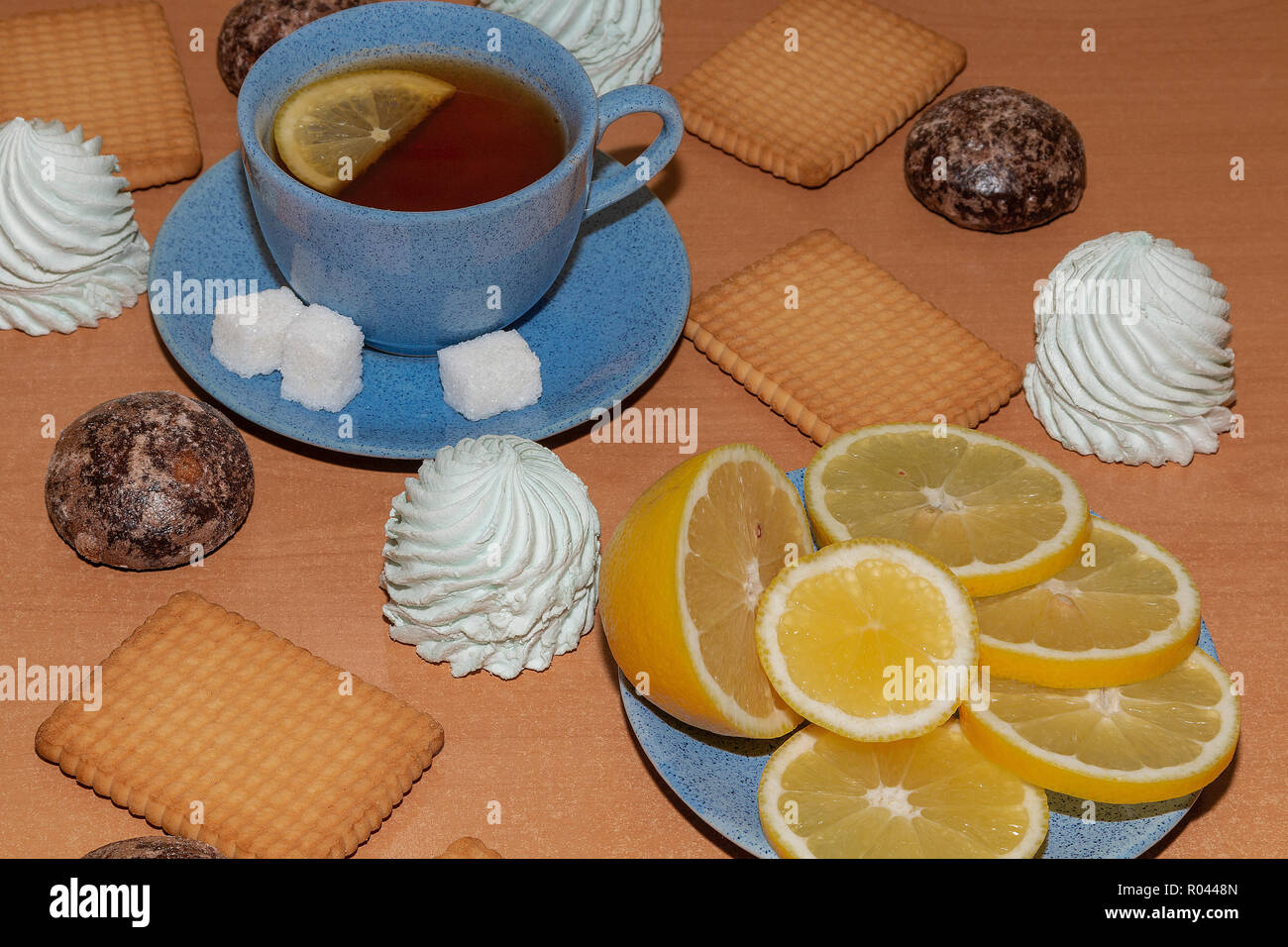 Zitrone, Eibisch, Lebkuchen und Plätzchen mit einer Tasse Tee auf einem hölzernen Hintergrund Stockfoto