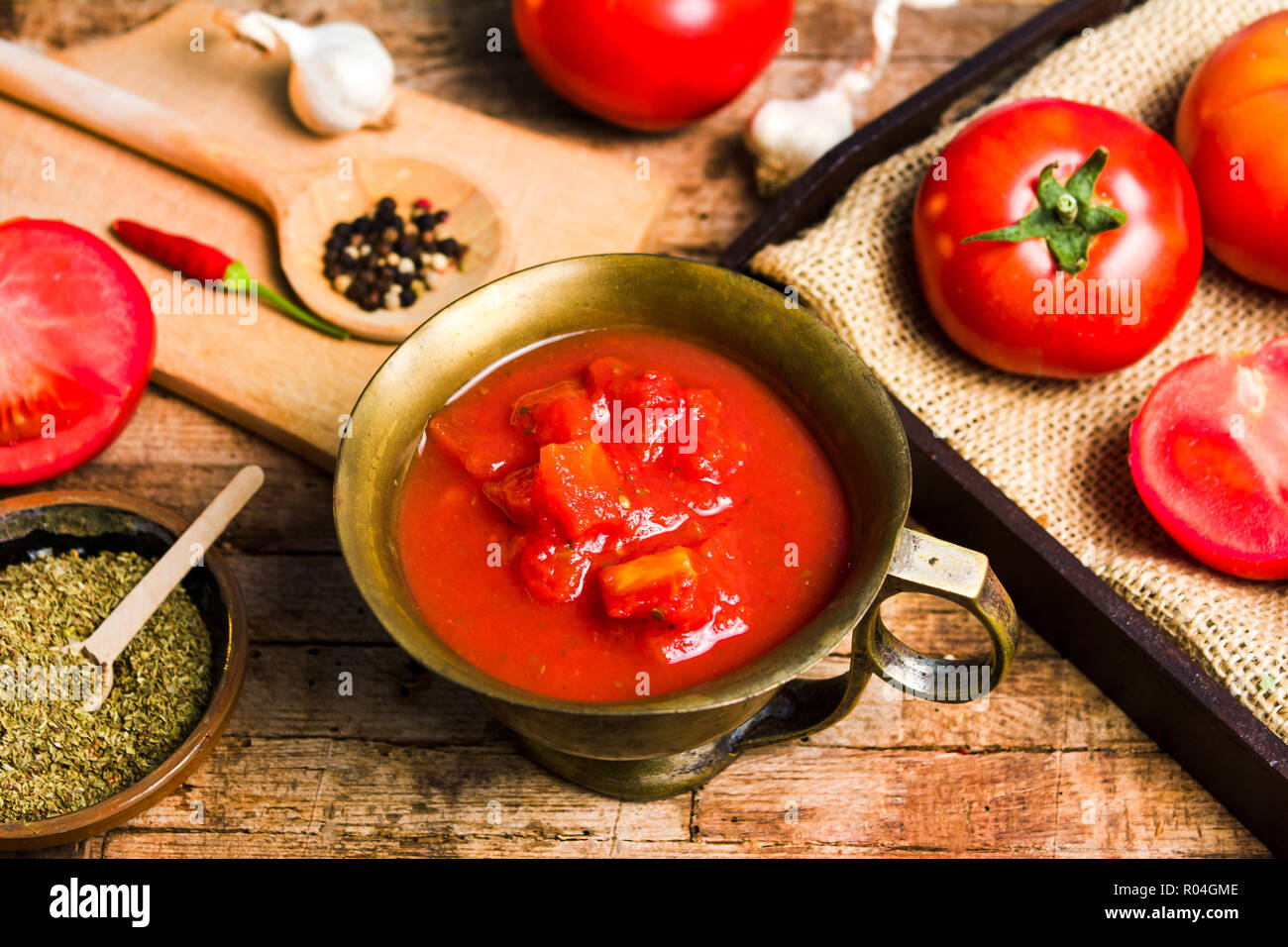 Tomaten und Tomatenmark auf einem rustikalen Holztisch, Ansicht von oben Stockfoto