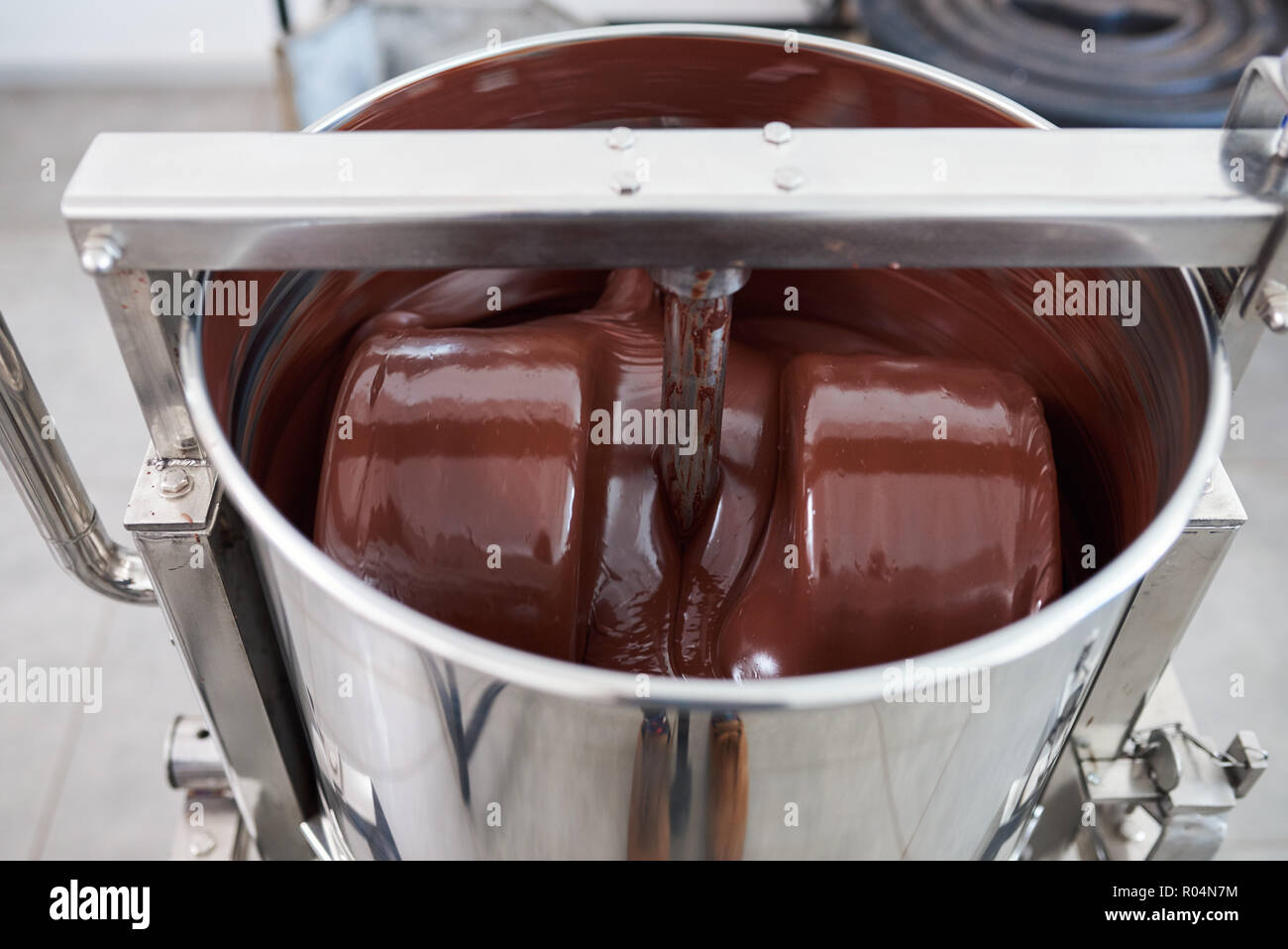 Geschmolzene Schokolade Mischen in einem Edelstahl Mixer Stockfoto