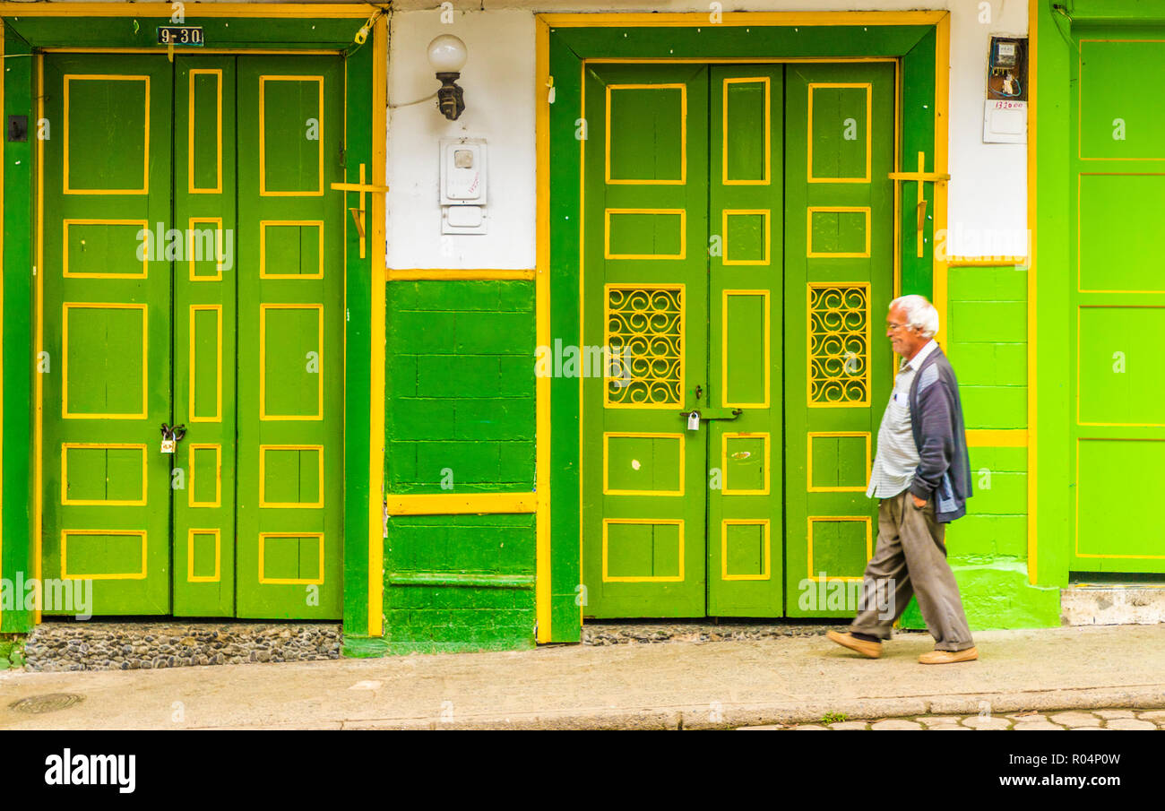 Ein lokaler Mann zu Fuß vorbei an einer in der Regel bunt, haltbar gemacht, Gebäude aus der Kolonialzeit, Jardin, Kolumbien, Südamerika Stockfoto