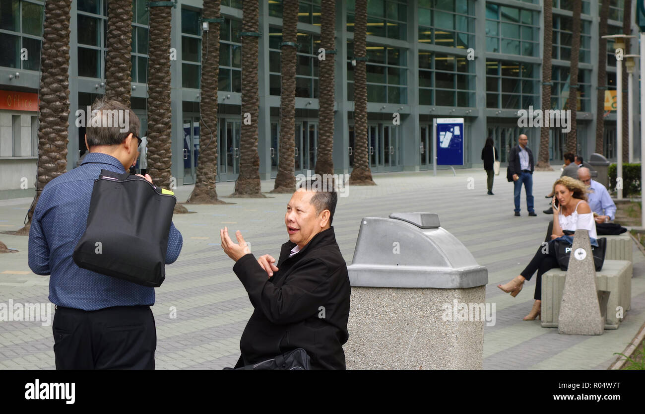 Zwei Teilnehmer (Asiatische Männer) in einer lebhaften Debatte außerhalb des Anaheim Convention Center Stockfoto