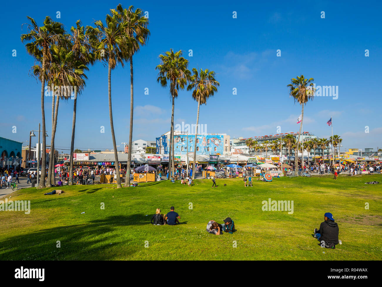 Blick auf Palmen und Besucher am Ocean Front Walk in Venice Beach, Los Angeles, Kalifornien, Vereinigte Staaten von Amerika, Nordamerika Stockfoto