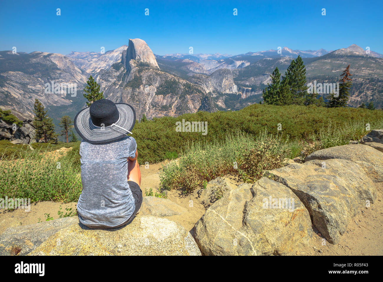 Reisende Frau suchen Panorama am Glacier Point im Yosemite National Park, Kalifornien, USA. Der Blick vom Glacier Point: Half Dome, Liberty Cap, Yosemite Valley und Nevada fallen. Sommer reisen Konzept Stockfoto