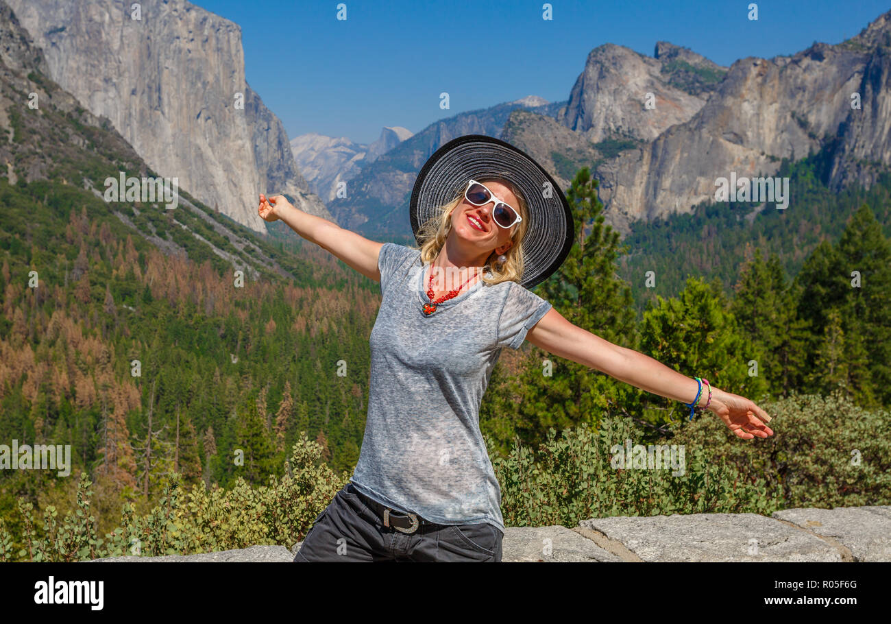 Traveler glückliche Frau genießen Panorama Aussichtspunkt am El Capitan im Yosemite National Park, Kalifornien, USA. Half Dome und Bridalveil Fall von iconic Tunnel anzuzeigen. Amerikanische Feiertage auf der Straße. Stockfoto