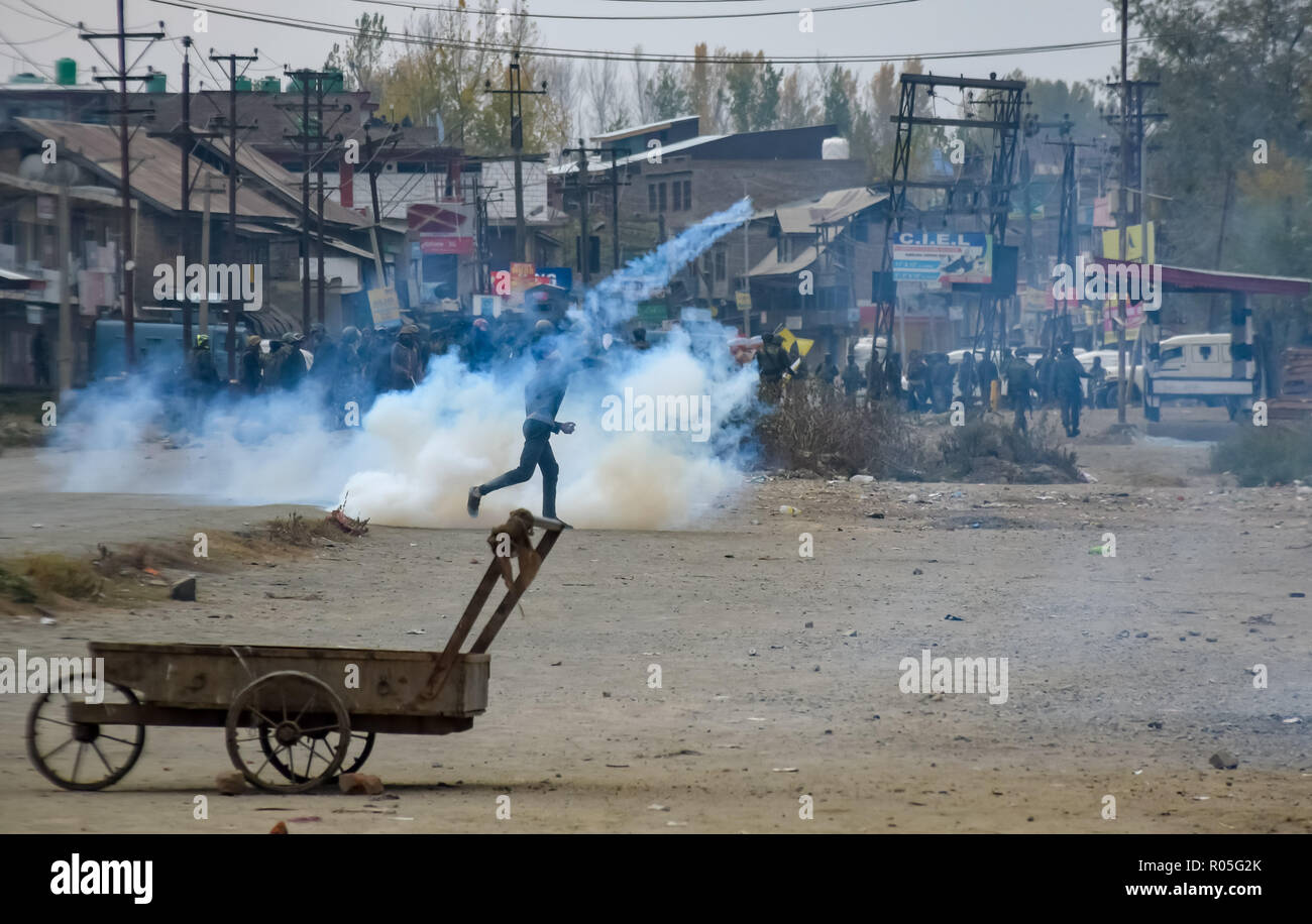 Kaschmir Maskierter Demonstrant gesehen das Wegwerfen einer zerlegten Gas rauch Kanister während der Auseinandersetzungen. Beamte sagen, daß zwei Rebellen in einem Schusswechsel mit der indischen Regierung Truppen getötet wurden, Auseinandersetzungen ausgebrochen im Bereich der Pampore Pulwama einige 20 km ab Sommer Hauptstadt Srinagar, nachdem die Nachricht verbreitete sich in der ganzen Gegend. Stockfoto
