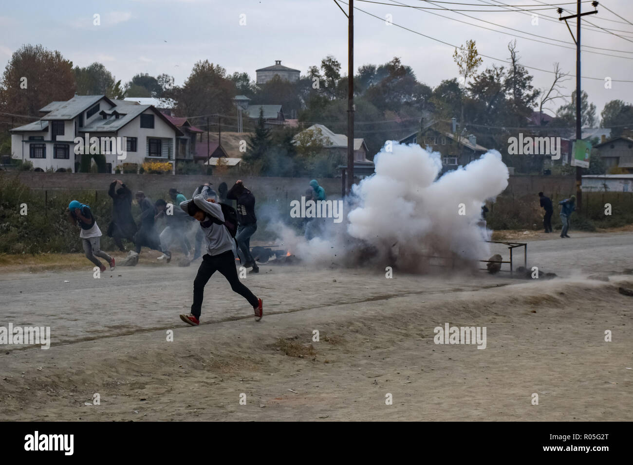 Kaschmir Demonstranten gesehen werden, die für die Abdeckung der indischen Truppen Lob-gas Rauch Kanister neben Ihnen bei den Auseinandersetzungen. Beamte sagen, daß zwei Rebellen in einem Schusswechsel mit der indischen Regierung Truppen getötet wurden, Auseinandersetzungen ausgebrochen im Bereich der Pampore Pulwama einige 20 km ab Sommer Hauptstadt Srinagar, nachdem die Nachricht verbreitete sich in der ganzen Gegend. Stockfoto