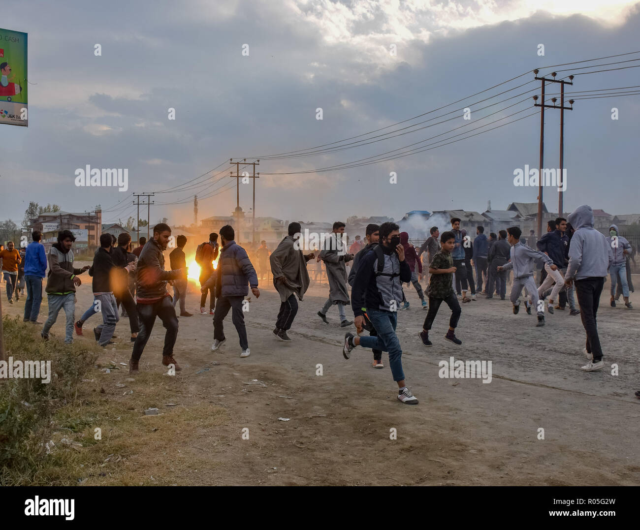 Kaschmir Demonstranten gesehen werden, die für die Abdeckung der indischen Truppen Lob-gas Rauch Kanister reißen Sie mitten während der Auseinandersetzungen. Beamte sagen, daß zwei Rebellen in einem Schusswechsel mit der indischen Regierung Truppen getötet wurden, Auseinandersetzungen ausgebrochen im Bereich der Pampore Pulwama einige 20 km ab Sommer Hauptstadt Srinagar, nachdem die Nachricht verbreitete sich in der ganzen Gegend. Stockfoto