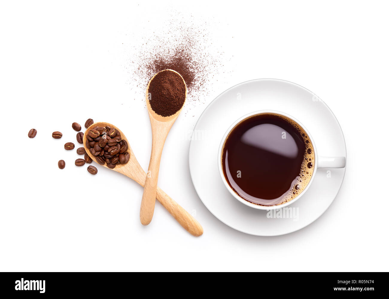 Kaffeebohnen und gemahlenen Kaffee auf hölzernen Löffel mit Tasse Kaffee schwarz auf weißem Hintergrund Stockfoto